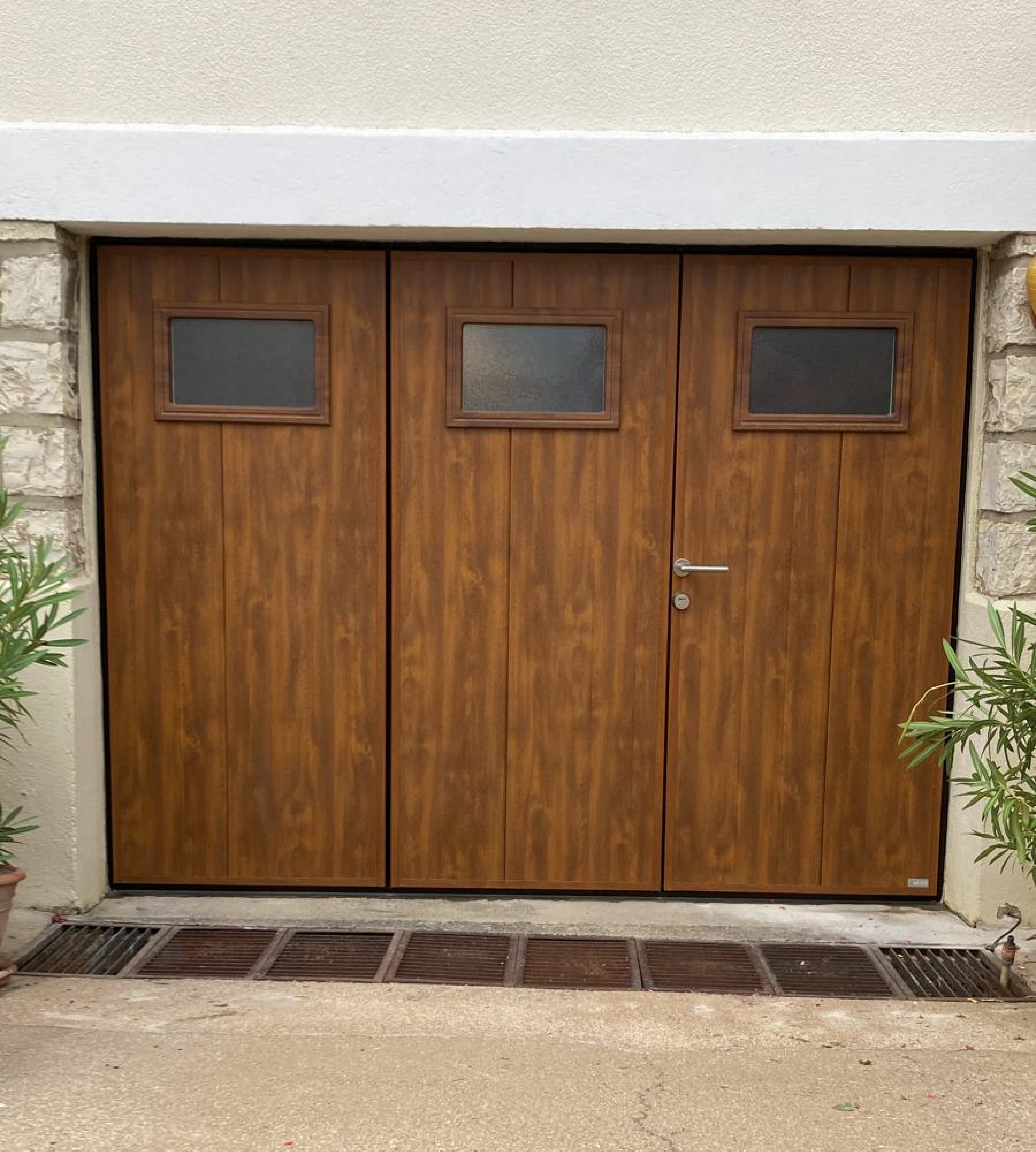 Porte de garage MOOS 3 vantaux imitation chêne doré avec 3 hublots rectangles